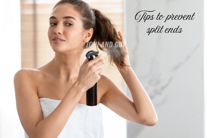 A woman applying hair care spray to prevent split ends, guided by TONI & GUY Coimbatore tips